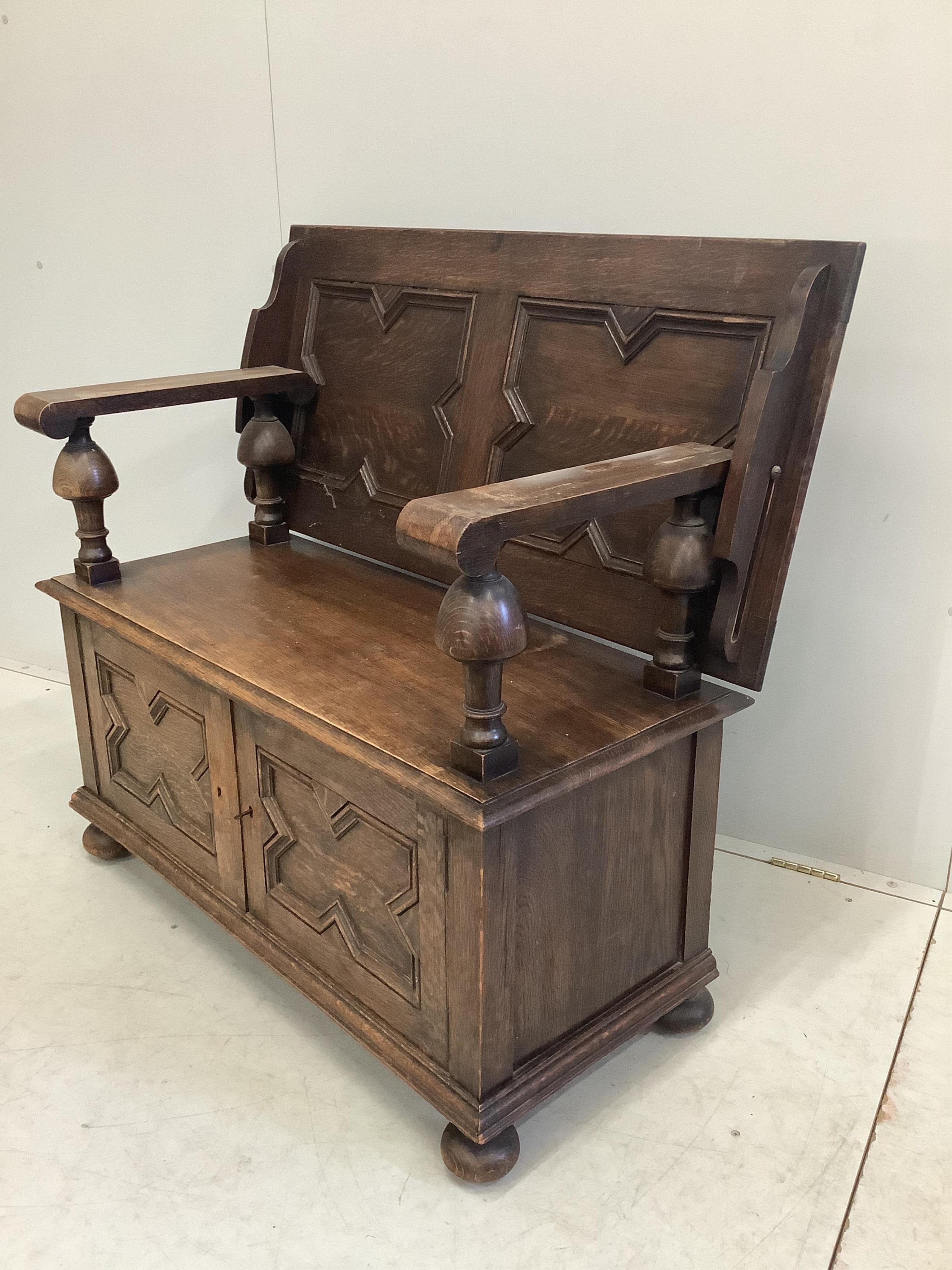 A 1920's oak monk's bench, width 107cm, depth 48cm, height 100cm. Condition - fair